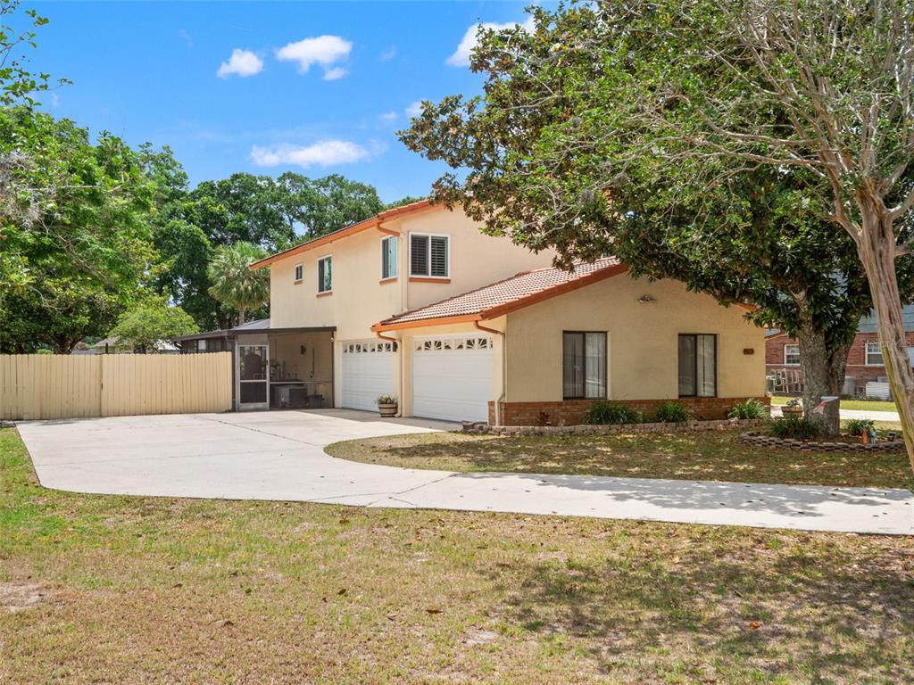 A two-story house with a two-car garage, a concrete driveway, and a large shade tree — 1161 W LAKE BRANTLEY ROAD, ALTAMONTE SPRINGS, FL