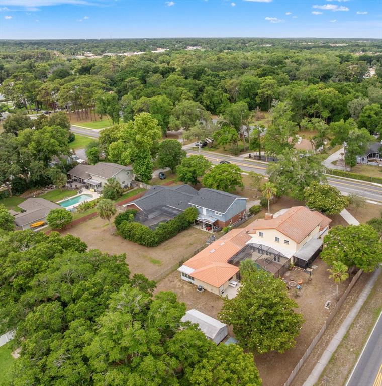 An aerial view shows several suburban houses with swimming pools and large trees — 1161 W LAKE BRANTLEY ROAD, ALTAMONTE SPRINGS, FL
