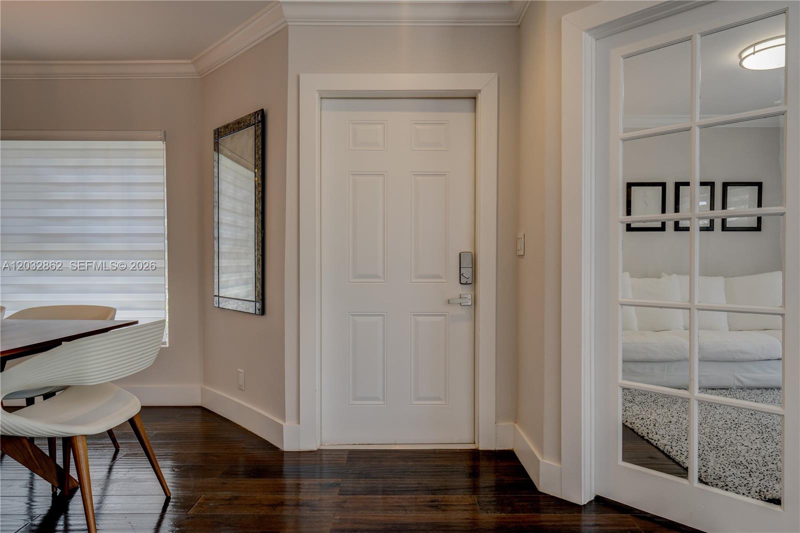 A dining area features a white door, a glass-paned door, and dark hardwood floors — WESTON, FL