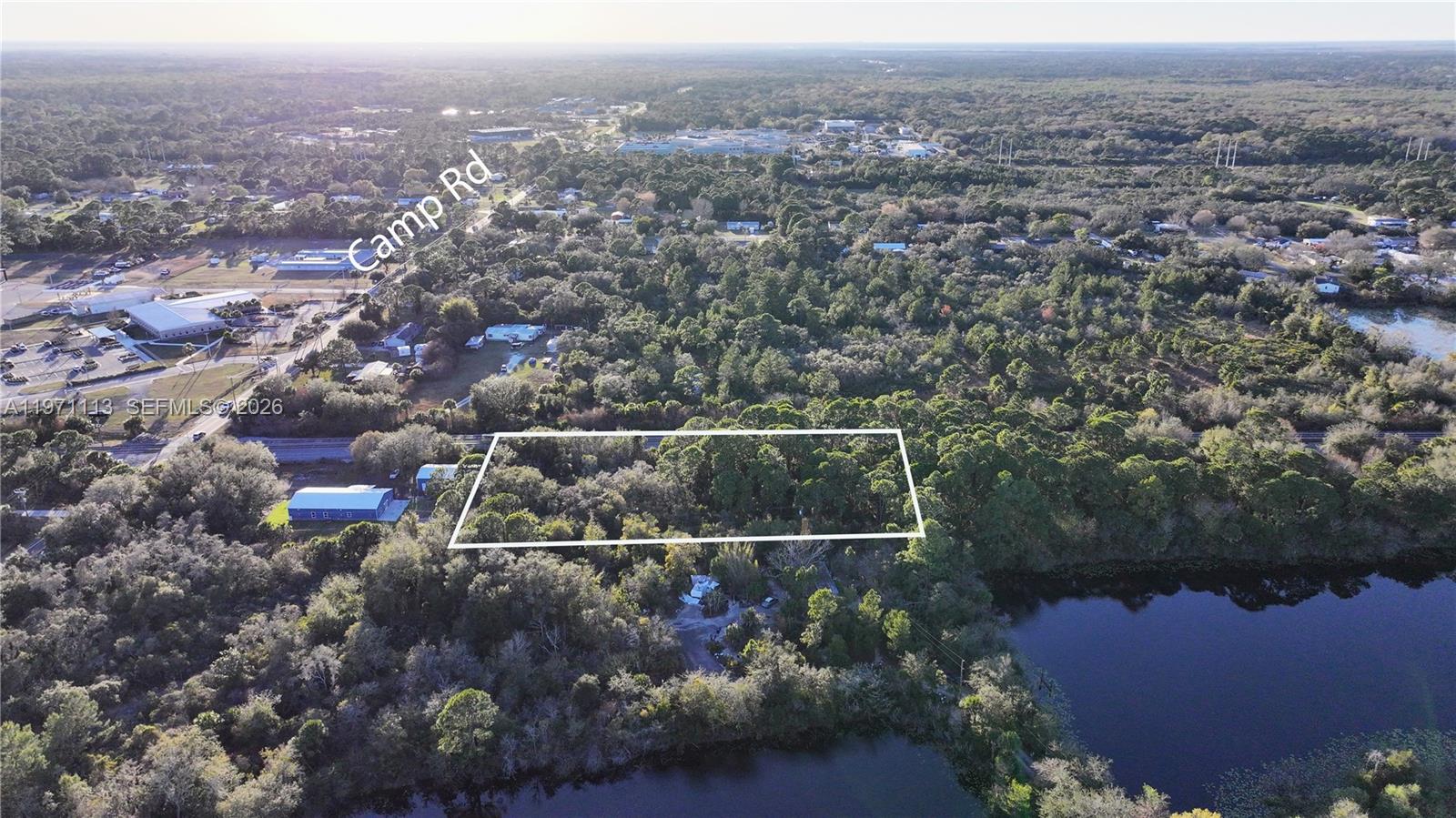 An aerial view shows a rectangular plot of land surrounded by trees and water — not assigned, Cocoa FL 32754, COCOA, FL