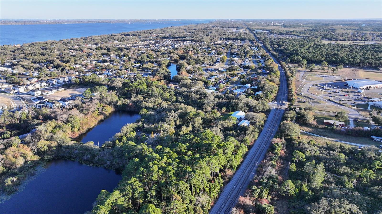 An aerial view shows a residential area, a railway line, and bodies of water — not assigned, Cocoa FL 32754, COCOA, FL