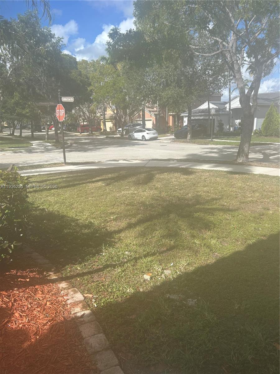 A view of a residential street intersection with a stop sign and surrounding trees — 948 NW Phoenix Way, Weston FL 33327, WESTON, FL