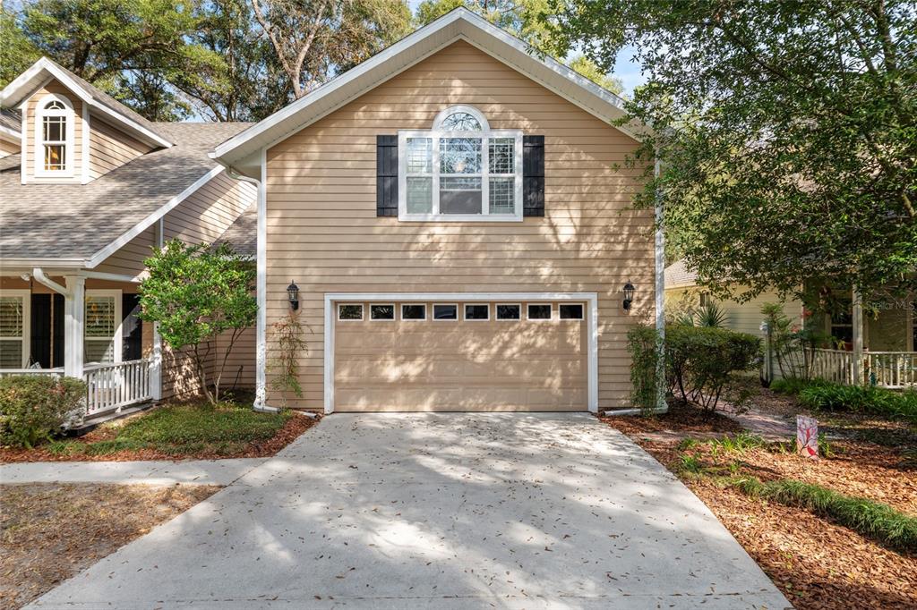 A two-story house with tan siding, a two-car garage, and a concrete driveway — 3773 SW 21ST DRIVE, GAINESVILLE, FL