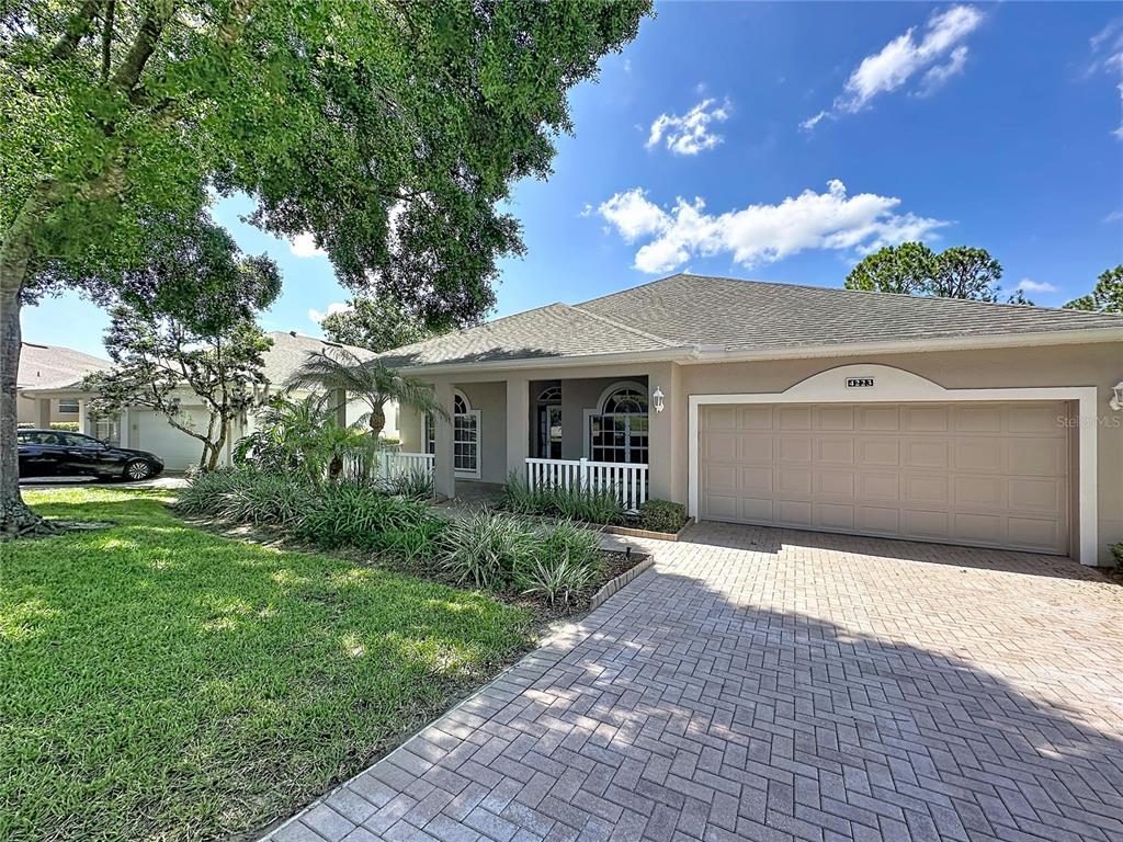 A single-story house with a beige stucco exterior, a two-car garage, and a paved driveway — 4223 KINGSLEY STREET, CLERMONT, FL