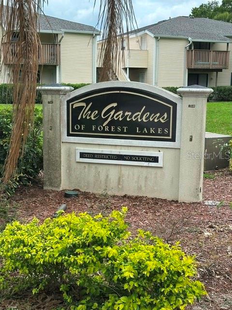 A sign for The Gardens of Forest Lakes stands in front of multi-story apartment buildings — 130 SABAL COURT UNIT H, OLDSMAR, FL