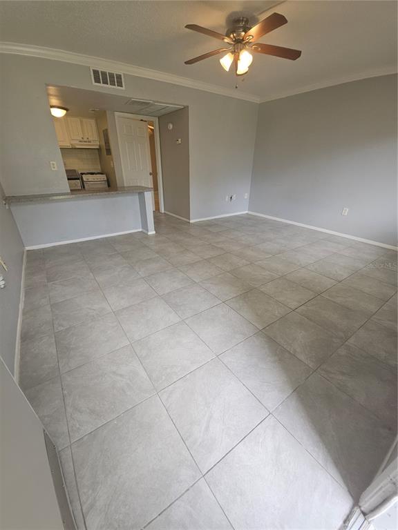 An open-concept living area features gray tile flooring, light gray walls, and a ceiling fan — 125 WATER FRONT WAY UNIT 130, ALTAMONTE SPRINGS, FL