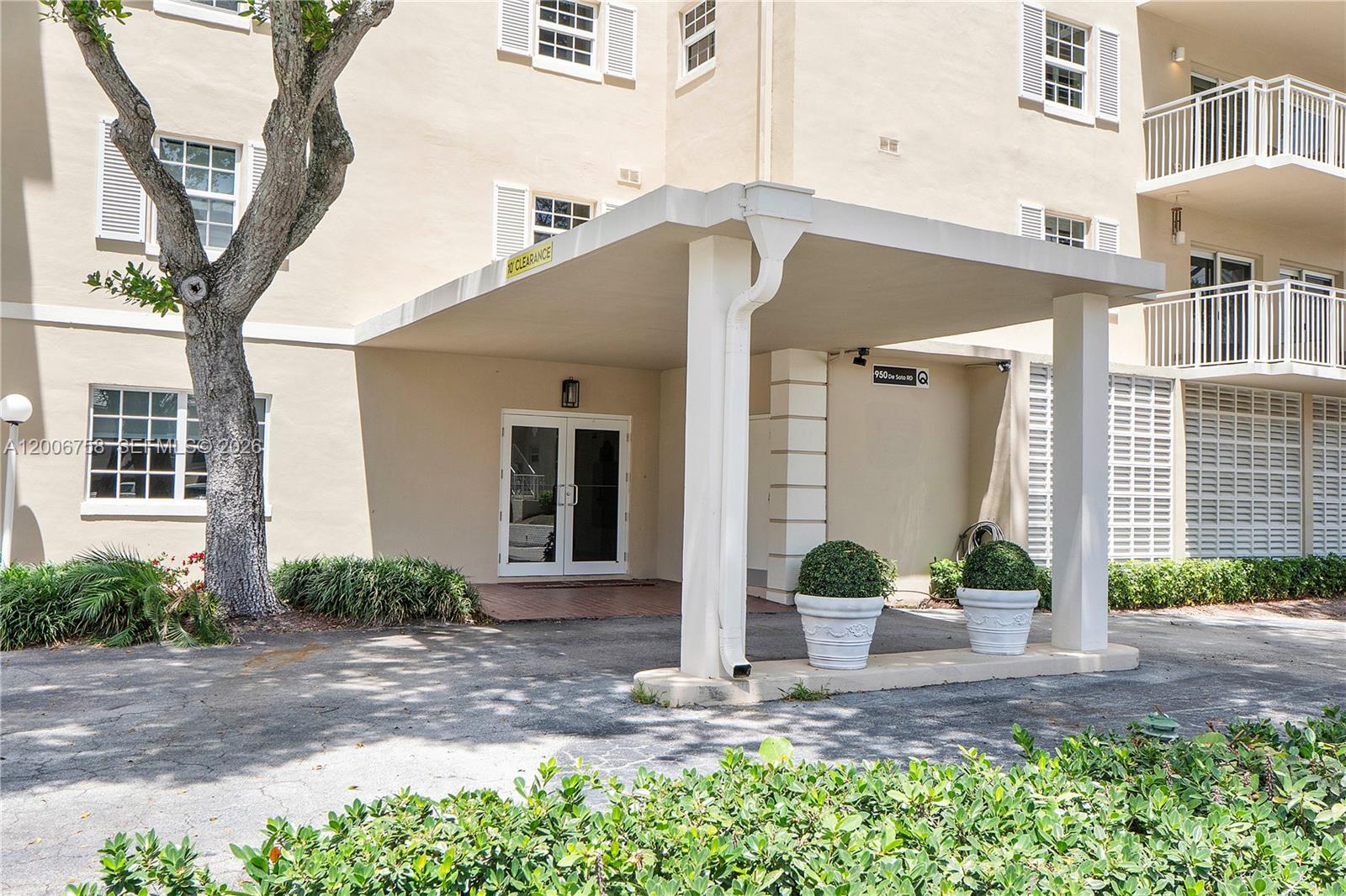 A spacious living room features a large red patterned rug, two sofas, and dining area — 950 De Soto Rd # 3C, Boca Raton FL 33432, BOCA RATON, FL