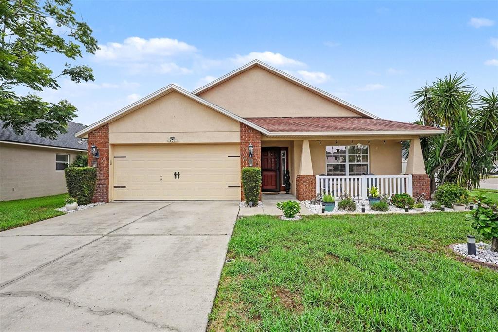 A single-story house with a beige stucco facade, brick accents, and a front porch — 12337 ROSE HAVEN BOULEVARD, NEW PORT RICHEY, FL