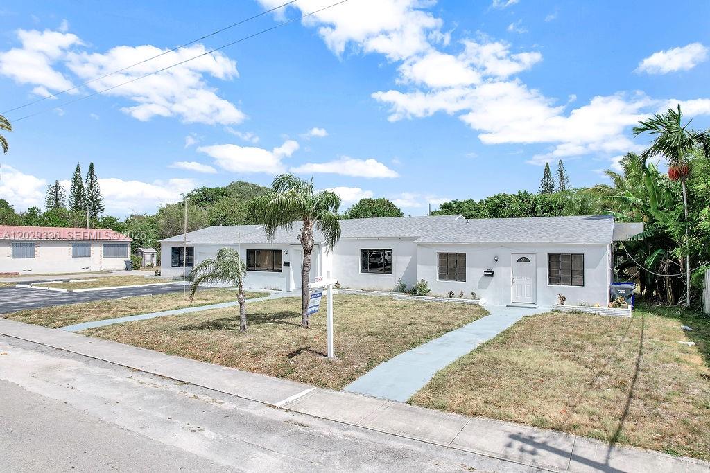 A single-story white house with a gray roof sits behind a lawn and sidewalk — 2415 Pierce St, Hollywood FL 33020, HOLLYWOOD, FL