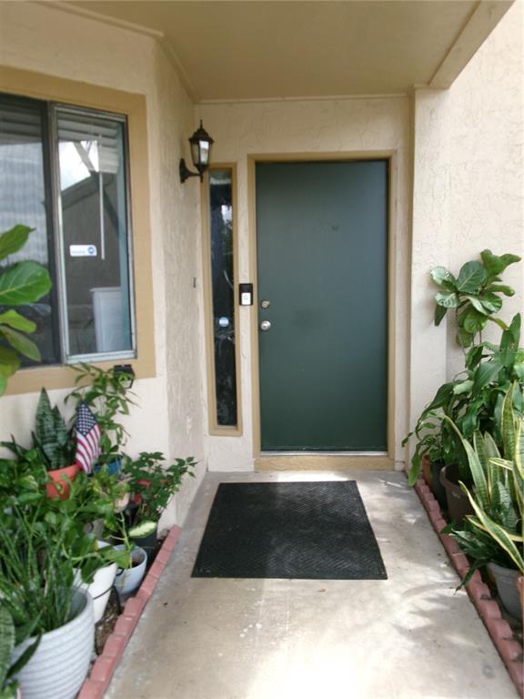 A front entryway features a dark green door, a side window, and several potted plants — 4324 MIDDLEBROOK ROAD UNIT 4324, ORLANDO, FL