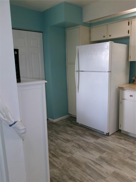 A kitchen features white cabinets, a white refrigerator, and light-colored wood-look flooring — 4324 MIDDLEBROOK ROAD UNIT 4324, ORLANDO, FL