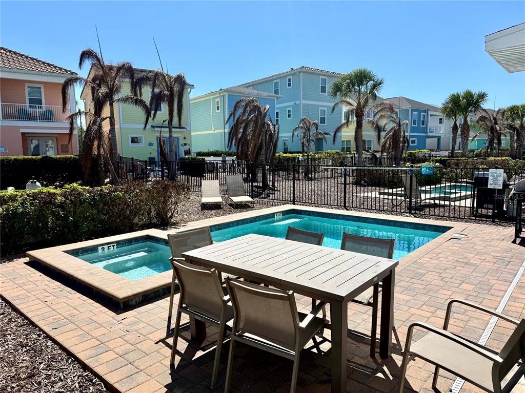 A patio features a dining set, a small swimming pool, and a hot tub — 8031 KNEE DEEP ROAD, KISSIMMEE, FL