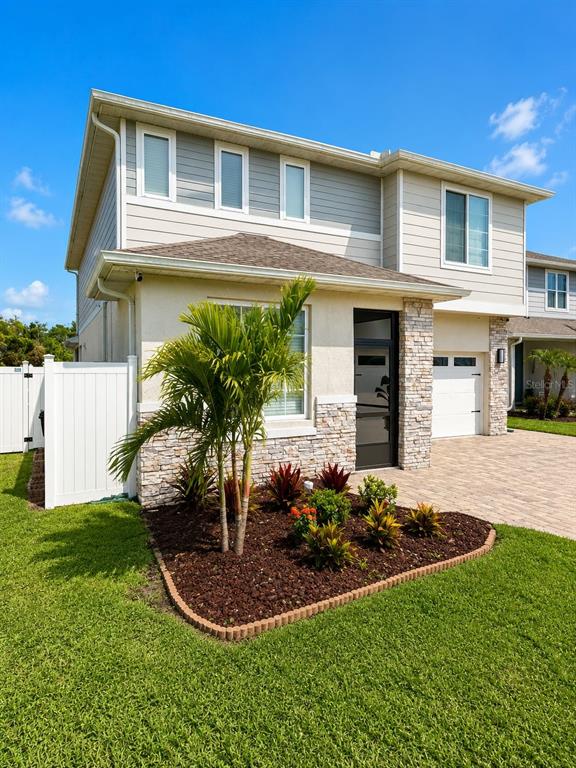 A two-story house features a stone-veneer facade, a palm tree, and a paved driveway — 4362 SOUTHERN VISTA LOOP, ST CLOUD, FL