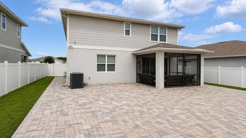 A two-story house features a paved patio and a screened-in porch in the backyard — 4362 SOUTHERN VISTA LOOP, ST CLOUD, FL