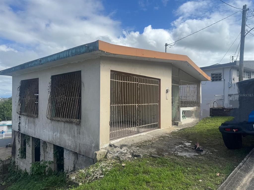 A two-story concrete house with metal security bars over the windows and front entrance — 487 EXT. VILLA DEL RIO, TOA ALTA, PR