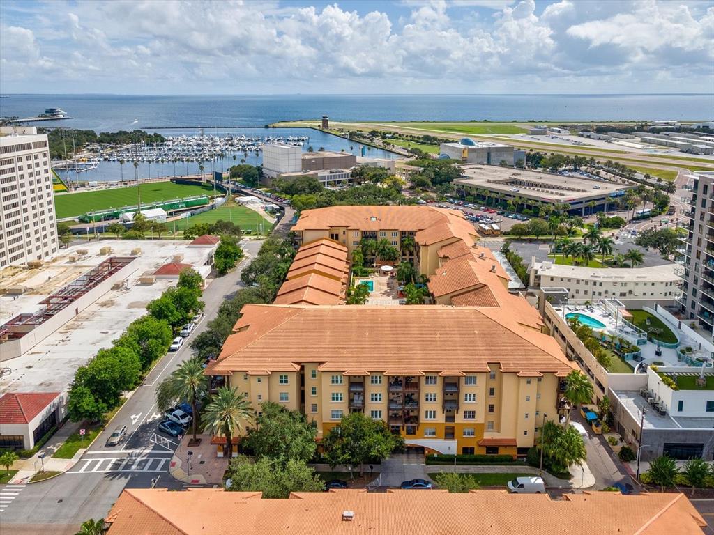 An aerial view shows a multi-story apartment complex with a central courtyard and pool — 100 4TH AVENUE S UNIT 416, ST PETERSBURG, FL