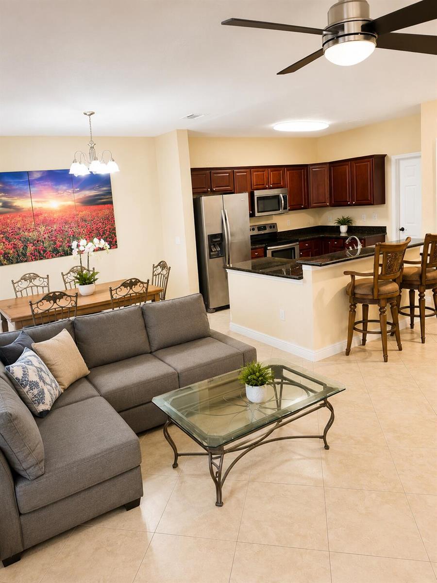 An open-concept living room, dining area, and kitchen with dark wood cabinets and tile floors — 4206 Emerald Vista, Lake Worth FL 33461, LAKE WORTH, FL