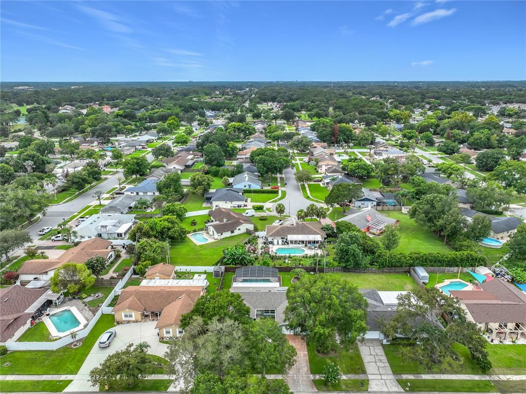An aerial view of a suburban neighborhood featuring numerous single-family homes with swimming pools — 8078 NICKLAUS DRIVE, ORLANDO, FL