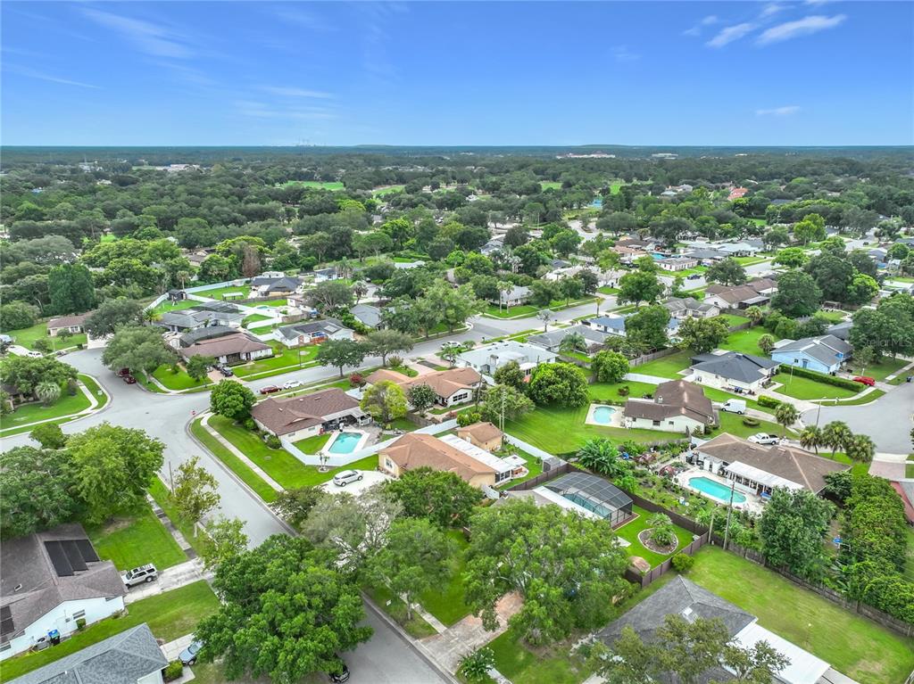 An aerial view shows a suburban neighborhood with single-family homes, swimming pools, and green lawns — 8078 NICKLAUS DRIVE, ORLANDO, FL