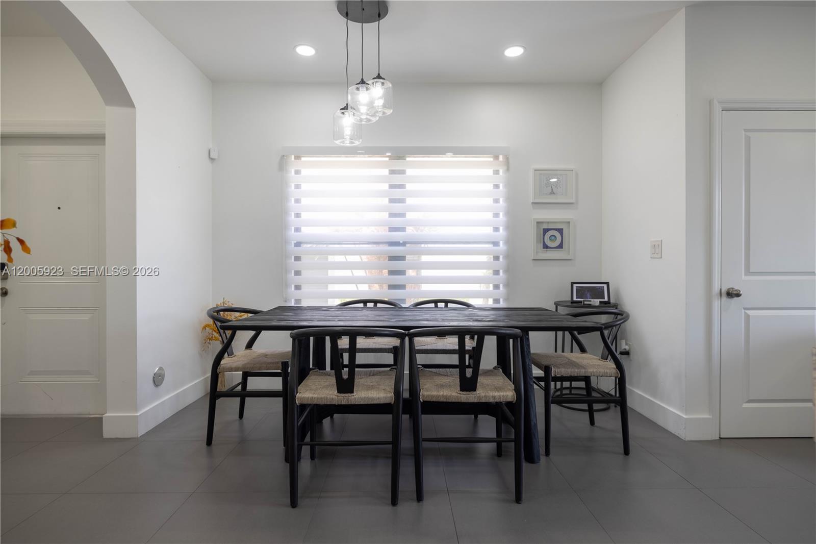 A dining room features a black wooden table, matching chairs, and a modern pendant light — 345 NE 194th Ln, Miami FL 33179, MIAMI, FL