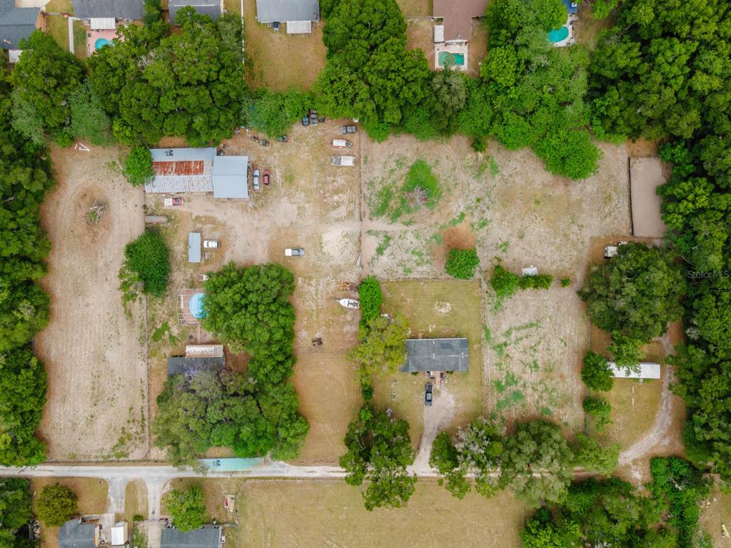 An aerial view shows a large, partially wooded residential lot with two houses and outbuildings — 4521 NE 28TH AVENUE, OCALA, FL