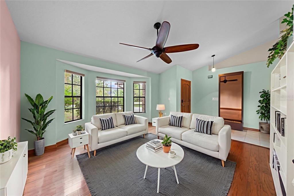 A living room features two white sofas, a round coffee table, and light green walls — 1860 MUSTANG COURT, ST CLOUD, FL