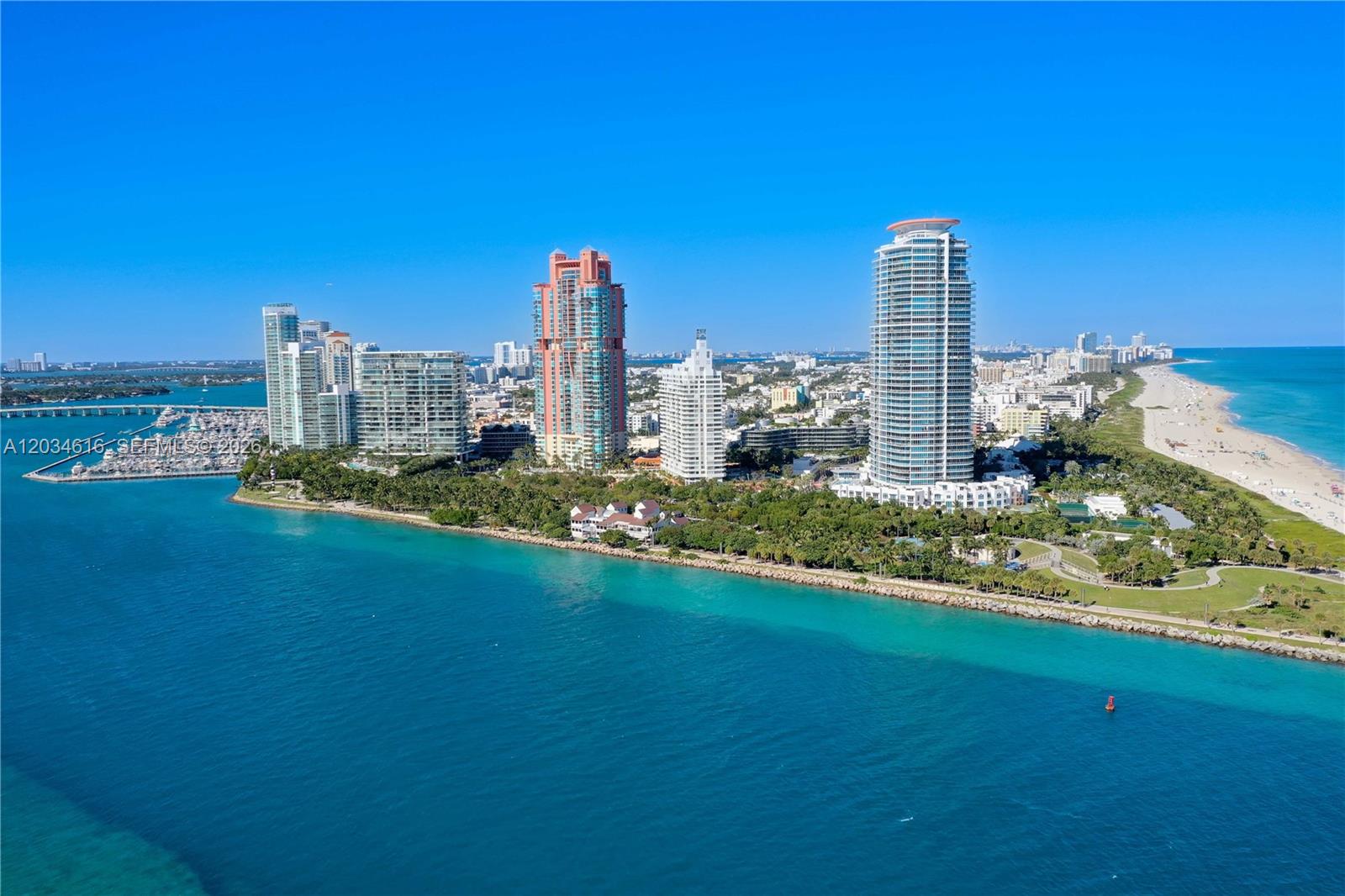 An aerial view shows high-rise buildings along a coastline with a beach and ocean — 100 S Pointe Dr # 1608, Miami Beach FL 33139, MIAMI BEACH, FL