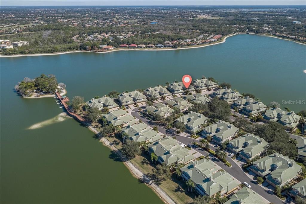 An aerial view shows a residential community of townhomes situated on a lakefront peninsula — 6515 MOORINGS POINT CIRCLE UNIT 102, LAKEWOOD RANCH, FL