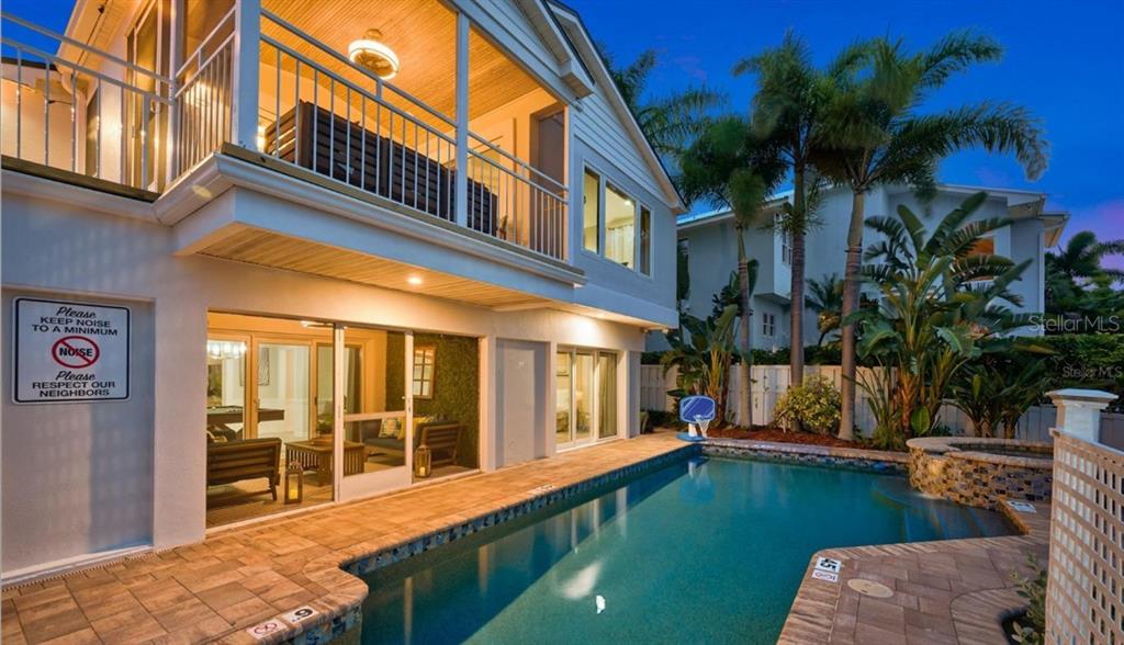 A two-story house with a balcony overlooks a swimming pool and a small hot tub — 4545 HARBOR HILLS DRIVE, LARGO, FL