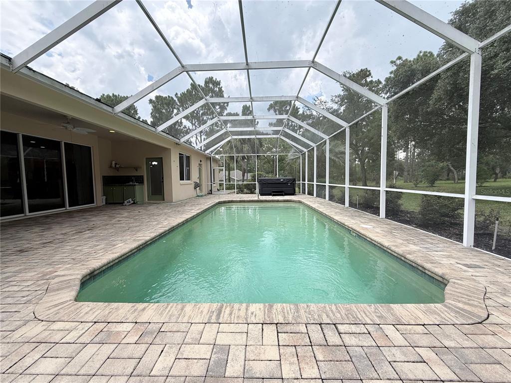 A rectangular swimming pool is enclosed by a screened lanai with paver decking — 4690 W TOMAHAWK DRIVE, BEVERLY HILLS, FL