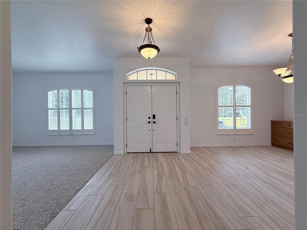 A foyer with light wood-look tile flooring, double front doors, and two arched windows — 4690 W TOMAHAWK DRIVE, BEVERLY HILLS, FL
