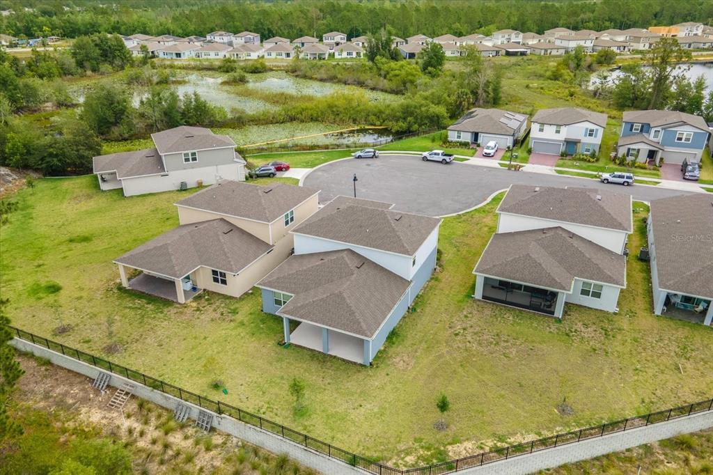 An aerial view shows several suburban houses with brown roofs surrounding a paved cul-de-sac — 17315 MILLION LAKES COURT, CLERMONT, FL