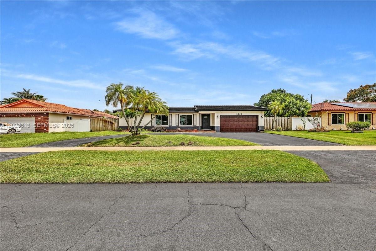 The exterior of a house features a dark front door, a garage, and stone landscaping — 5260 SW 10th Ct, Plantation FL 33317, PLANTATION, FL