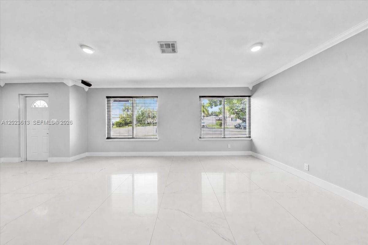 A spacious, empty room features light gray walls, white tile flooring, and two large windows — 5260 SW 10th Ct, Plantation FL 33317, PLANTATION, FL