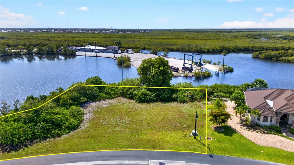An aerial view shows a vacant residential lot bordered by a road and waterfront mangroves — 5408 SEA EDGE DRIVE, PUNTA GORDA, FL