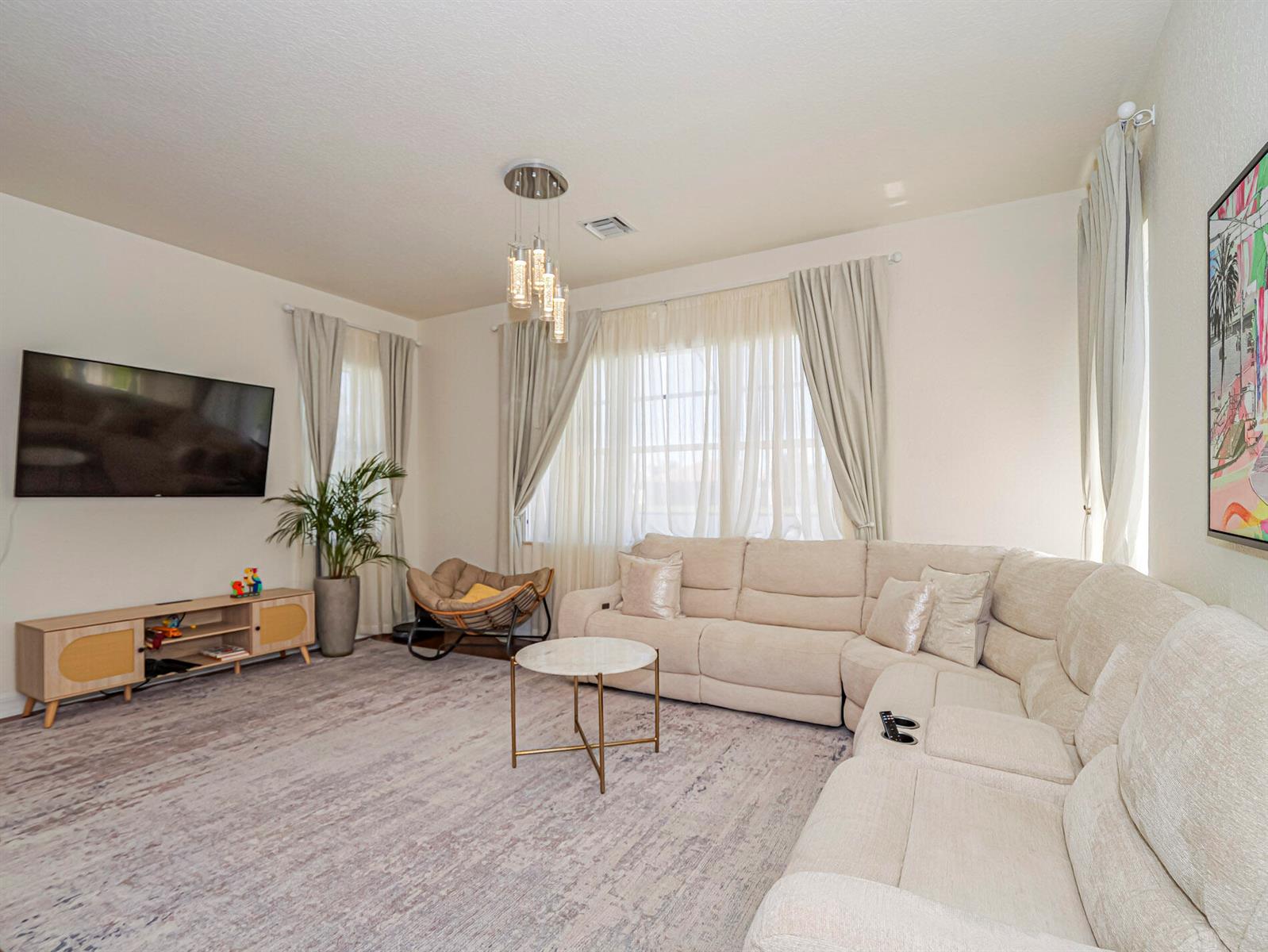 A living room features a large sectional sofa, a television, and a round coffee table — 5558 55th Avenue, Vero Beach FL 32967, VERO BEACH, FL