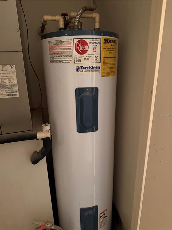 A white Rheem electric water heater is installed in a utility closet — 1401 S PALMETTO AVENUE UNIT 201, DAYTONA BEACH, FL