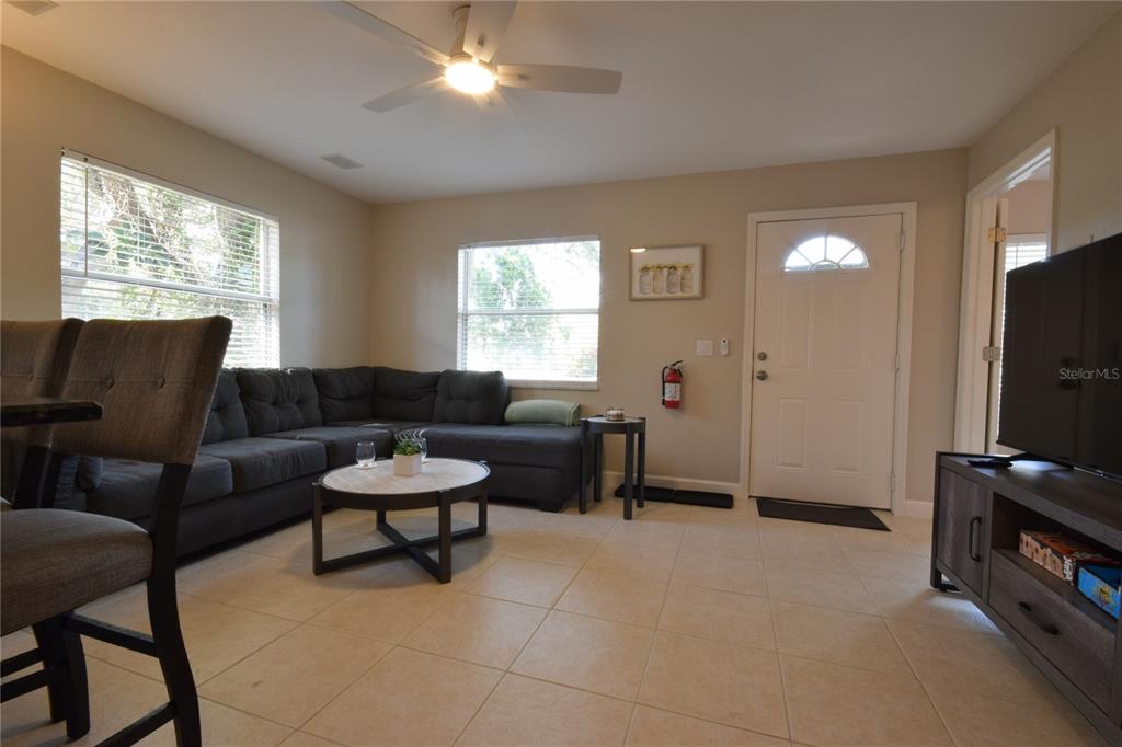 A living room features a sectional sofa, a round coffee table, and tile flooring — 306 BAILEY LANE, SARASOTA, FL