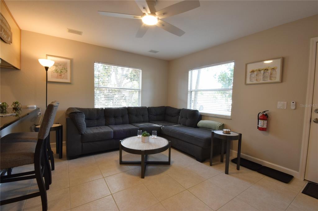 A living room features a large gray sectional sofa, a round coffee table, and tile flooring — 306 BAILEY LANE, SARASOTA, FL