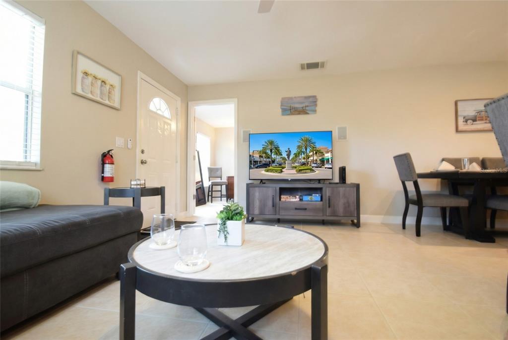 A living room features a grey sofa, a round coffee table, and a television console — 306 BAILEY LANE, SARASOTA, FL