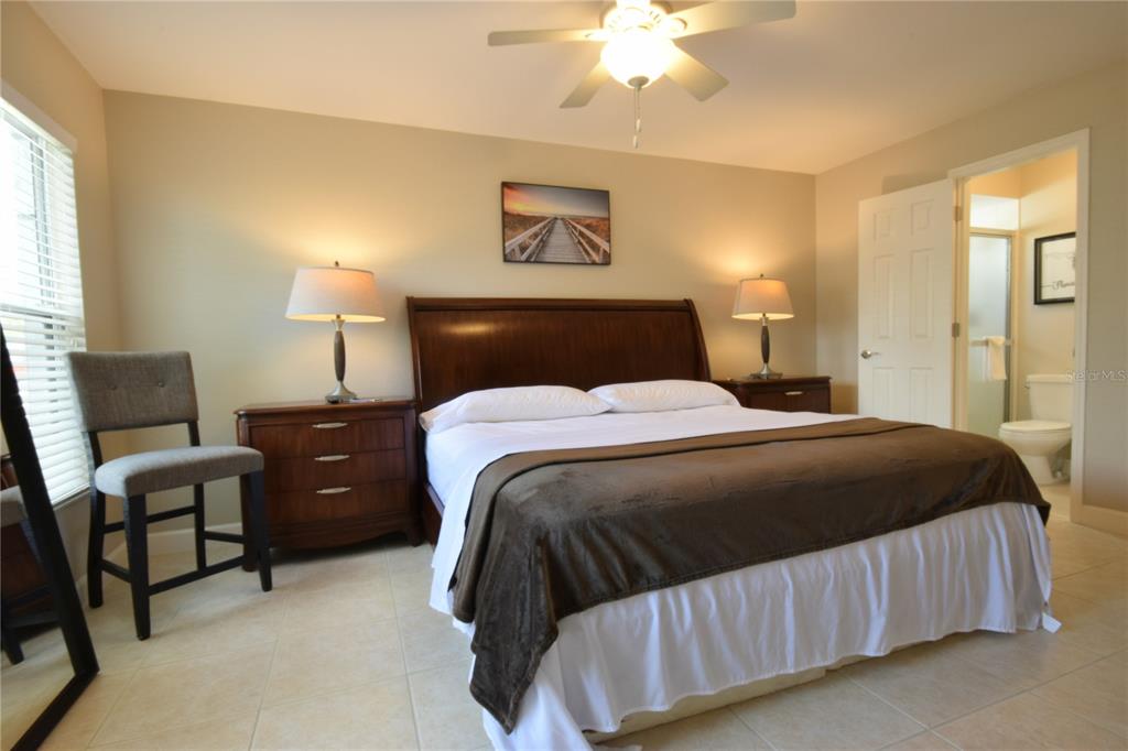 A bedroom features a wooden bed frame, two nightstands with lamps, and an attached bathroom — 306 BAILEY LANE, SARASOTA, FL