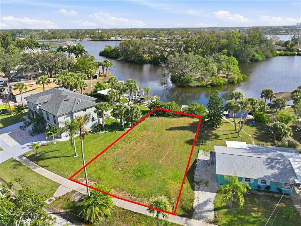 An aerial view shows a vacant rectangular lot outlined in red between two houses — 56 INNESS DRIVE, TARPON SPRINGS, FL