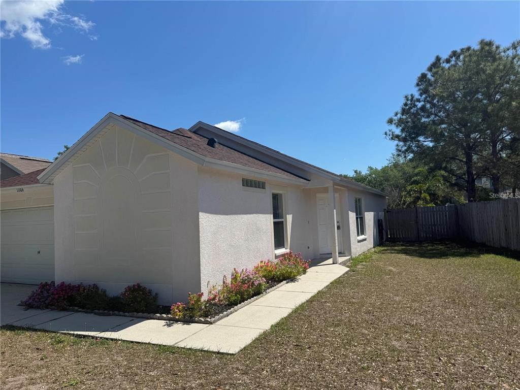 A single-story house with a stucco exterior, a concrete walkway, and a small flower bed — 11106 HAVASU COURT, RIVERVIEW, FL