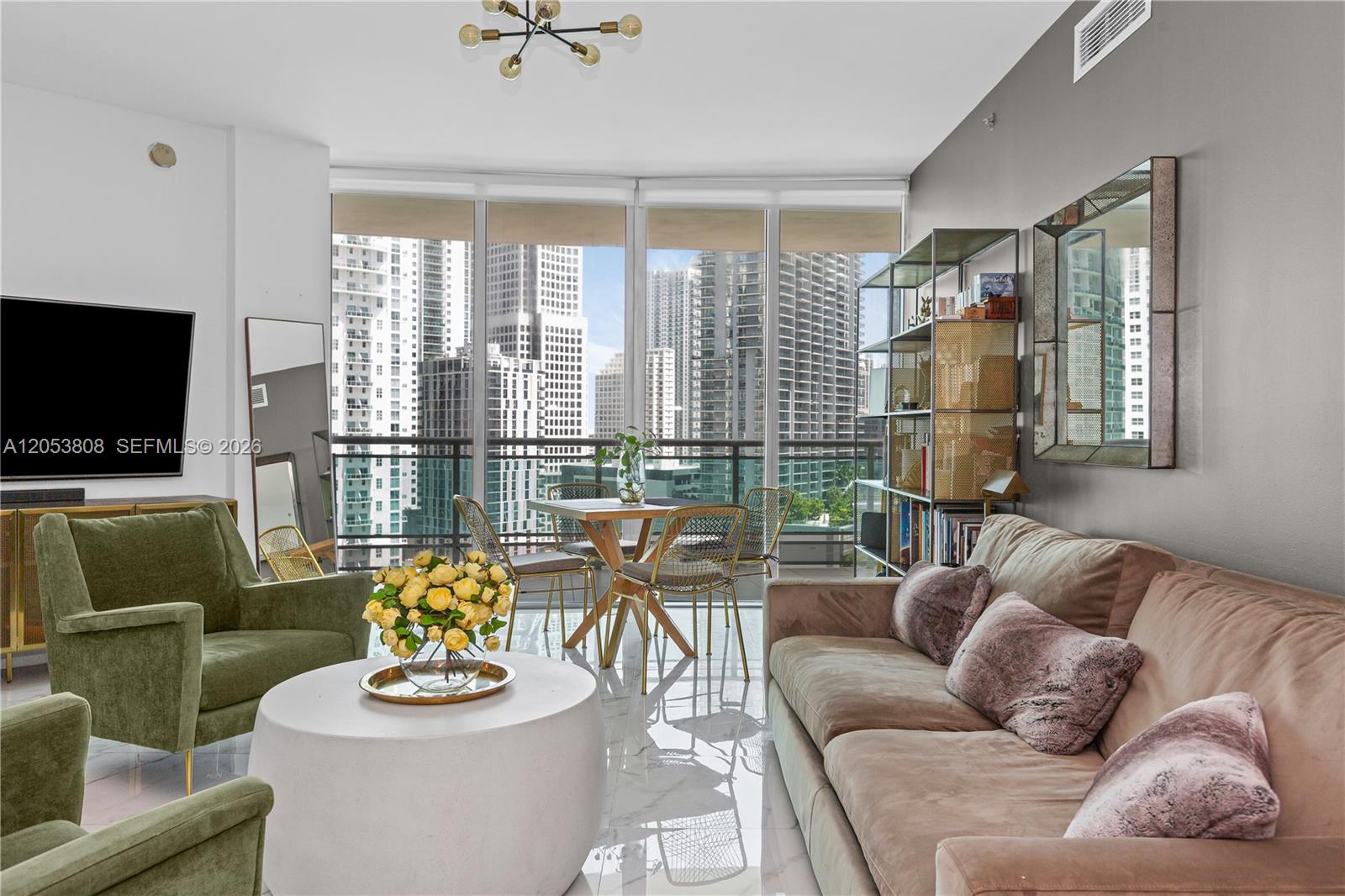 A modern living and dining area features floor-to-ceiling windows overlooking a dense city skyline — 350 S Miami Ave # 2102, Miami FL 33130, MIAMI, FL