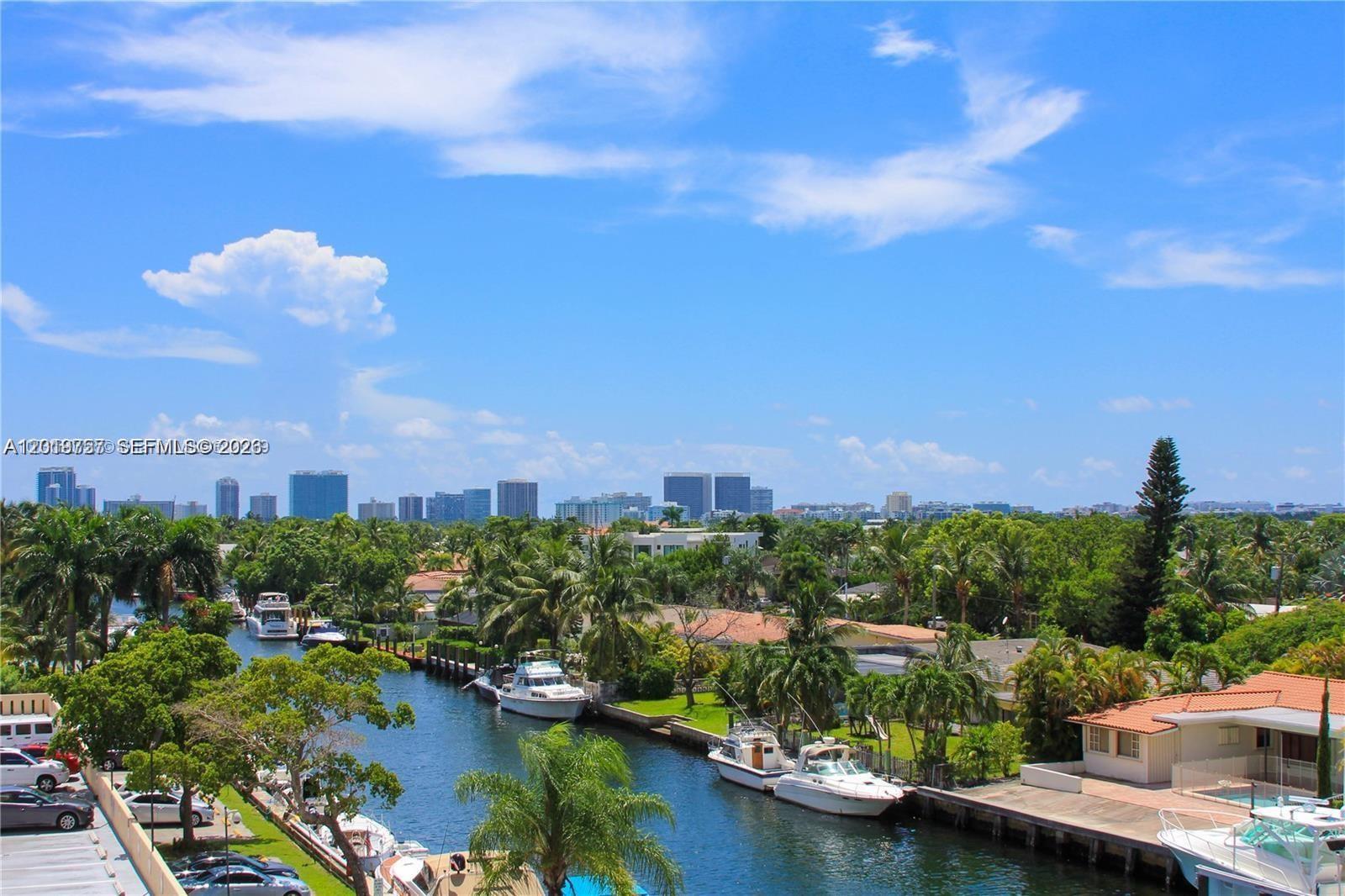 An elevated view shows a canal lined with boats and houses leading toward a city skyline — 2350 NE 135th St # 507, North Miami FL 33181, NORTH MIAMI, FL