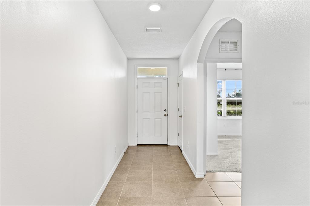 A tiled entryway leads to a white front door with an arched opening to the right — 3909 PARK WILLOW AVENUE, PALMETTO, FL
