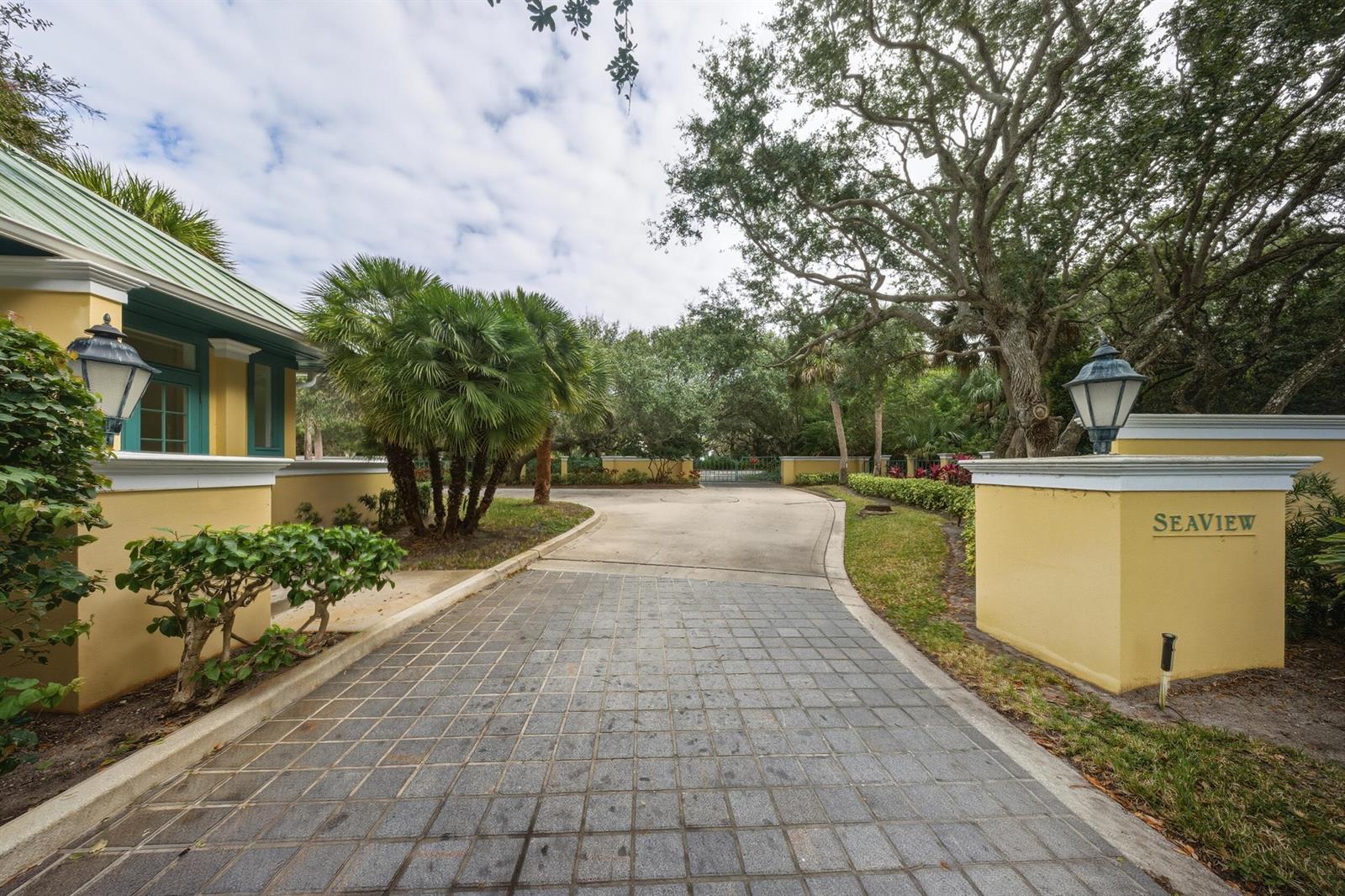A paved driveway leads to a gated entrance marked by a yellow pillar labeled Seaview — 11740 Seaview Drive, Vero Beach FL 32963, VERO BEACH, FL