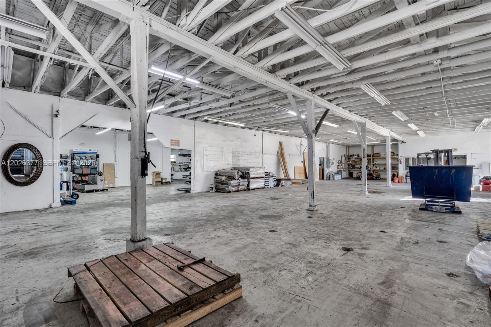 A large, open industrial warehouse space features exposed white rafters, concrete floors, and support columns — 921 N 21st Ave, Hollywood FL 33020, HOLLYWOOD, FL