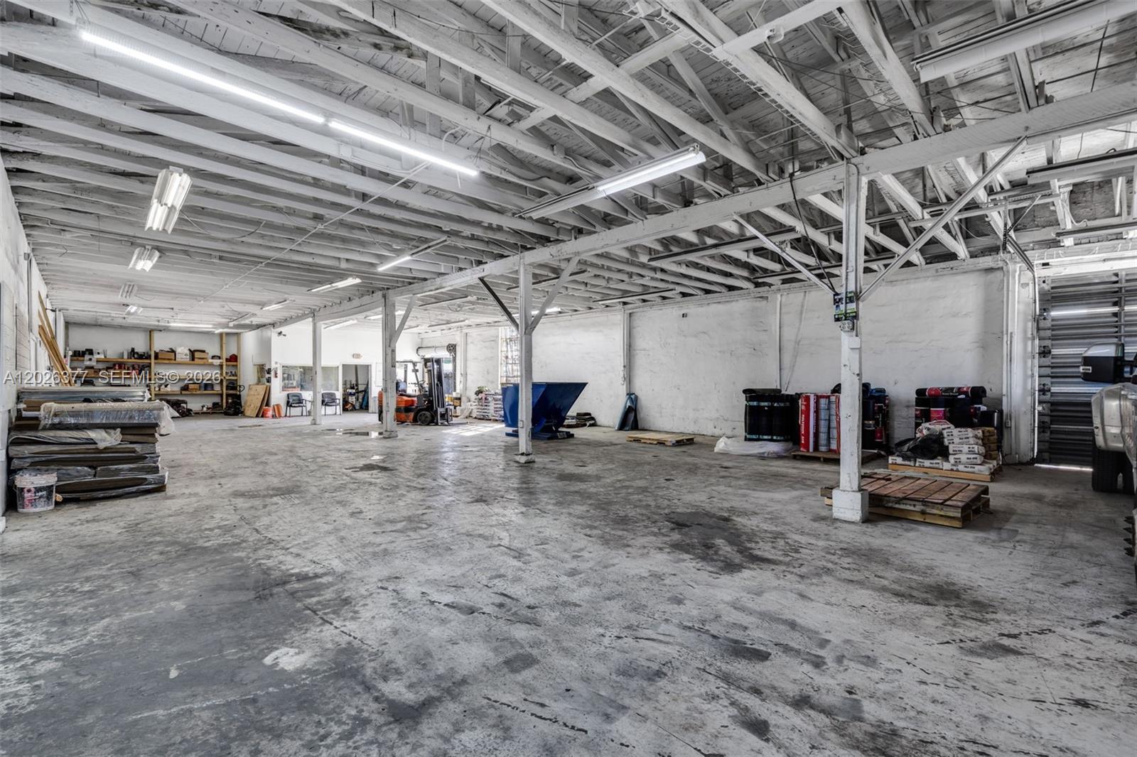 A large, open industrial warehouse space features exposed wooden rafters, concrete floors, and support columns — 921 N 21st Ave, Hollywood FL 33020, HOLLYWOOD, FL