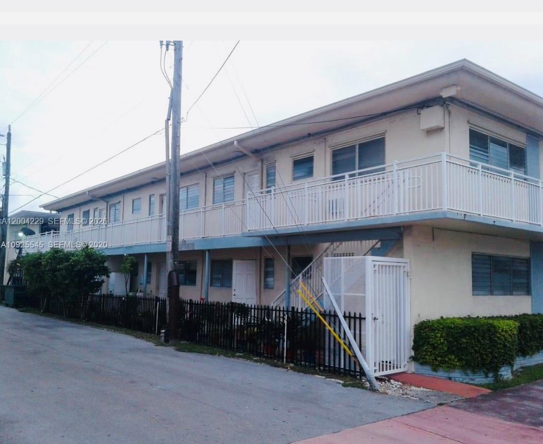 A two-story apartment building with exterior walkways, metal railings, and a fenced ground-level entrance — 350 75th St # 109, Miami Beach FL 33141, MIAMI BEACH, FL